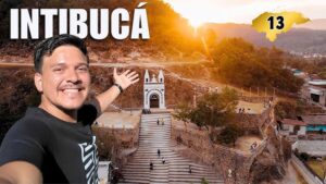 Un hombre sonriente se toma una selfie frente a una escalinata y arco blanco en un mirador de Intibucá, Honduras.