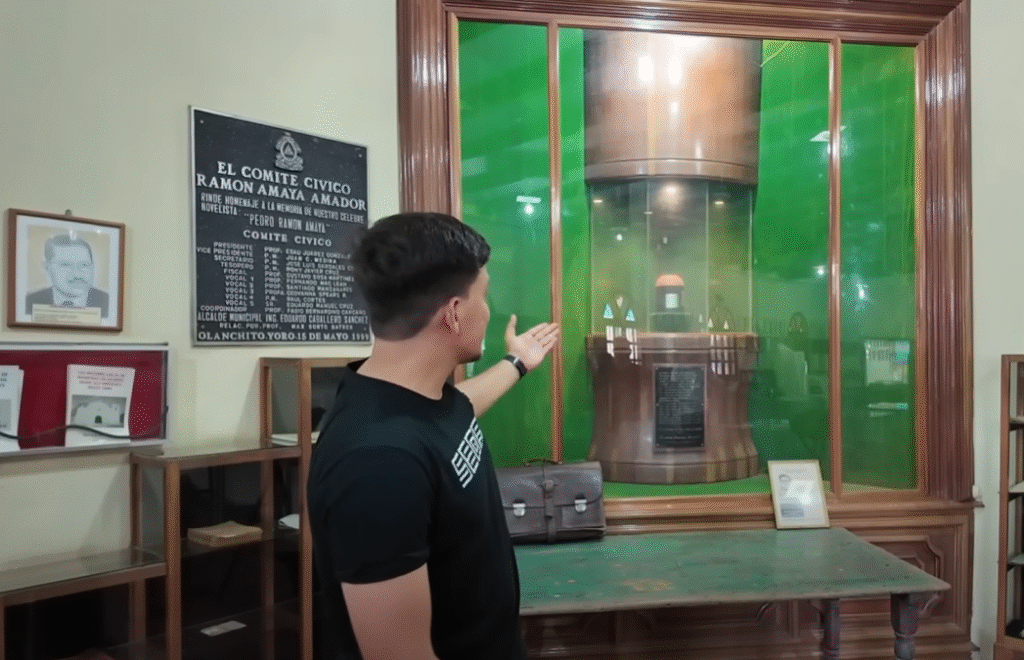Hombre señalando una vitrina con un objeto histórico en un museo de Yoro, Honduras.