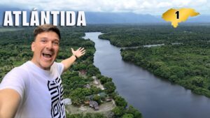 Selfie de un hombre sonriendo con un río ancho rodeado de selva en el departamento de Atlántida, Honduras; el número 1 indica la región en la serie.