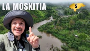 Un hombre con sombrero de safari señalando mientras se encuentra frente a un río y selva en La Mosquitia, Honduras.