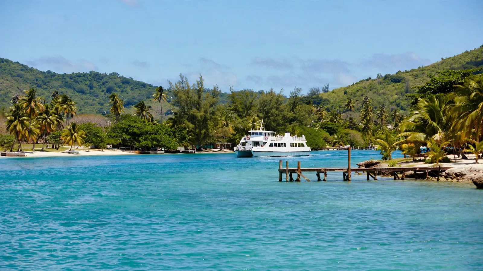 Ferry blanco acercándose al muelle de una isla caribeña